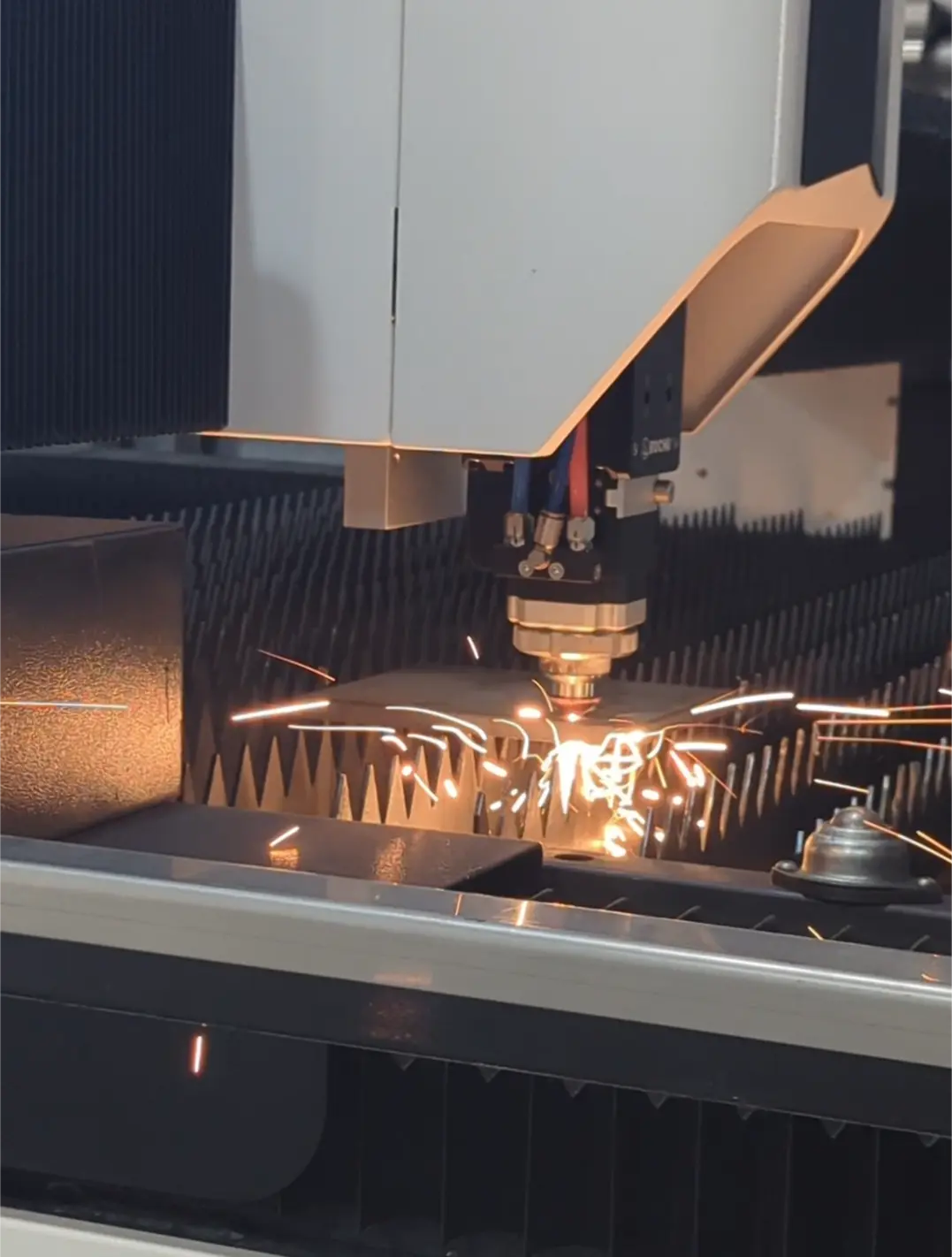 Laser cu fibră tăind tablă de inox, cu scântei