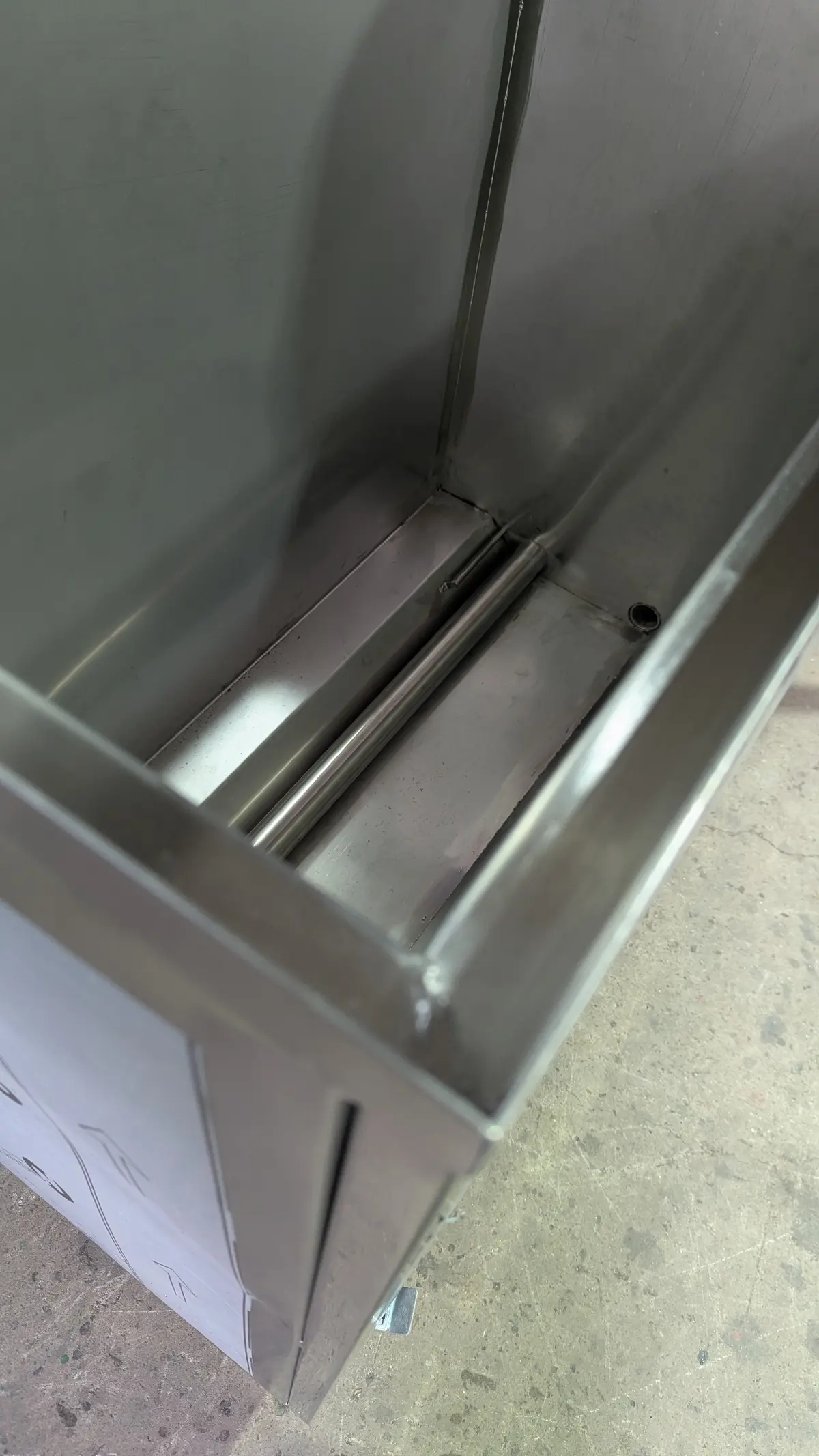 Interiorul unei cuve din inox, cu muchii îndoite și colțuri sudate
